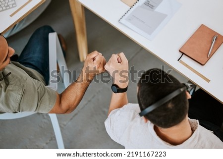 Excited call centre agents, fist bump and celebrating deal, promotion and sale from above in office. Motivated, happy and successful telemarketing colleagues or customer support operators cheering Royalty-Free Stock Photo #2191167223