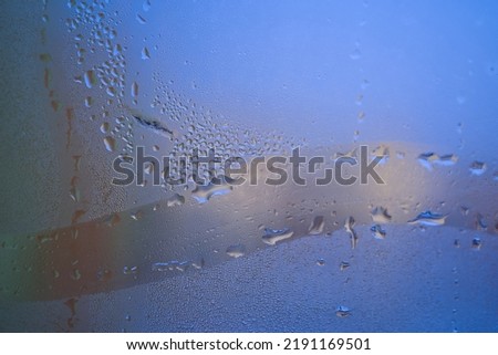 Water droplets or condensation on the outside of a cold windows in a close up full frame background texture Royalty-Free Stock Photo #2191169501