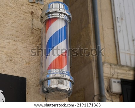 barber pole shop signboard cylindrical sign in vintage hairdresser wall white red blue colors