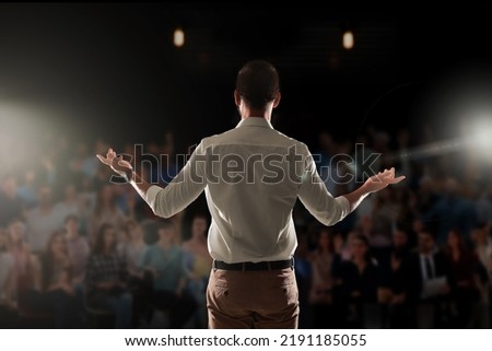 Motivational speaker with headset performing on stage, back view Royalty-Free Stock Photo #2191185055