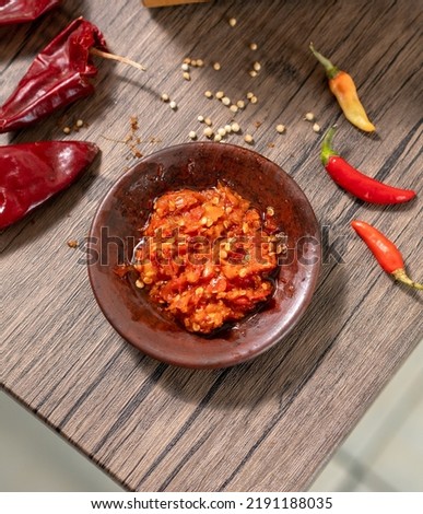 Traditional Indonesian Chili Sauce or Sambal Uleg. Made from Chili, Onion, Garlic, Tomato and Palm Oil. It's Made Using Uleg or Food Smasher from Claypot.  Royalty-Free Stock Photo #2191188035