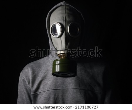 A man in a gas mask, on a black background. Ecological catastrophy.  Stalker. 