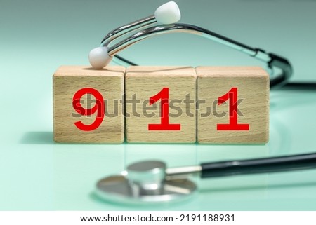 Emergency number 911, Red numbers on wooden blocks, Medical stethoscope, International contact number concept