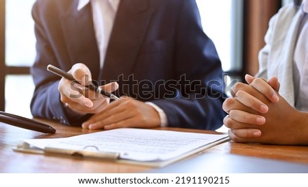 A professional male real estate agent or business consultant is meeting, talking, and giving business investment strategy advice to his client. cropped shot Royalty-Free Stock Photo #2191190215