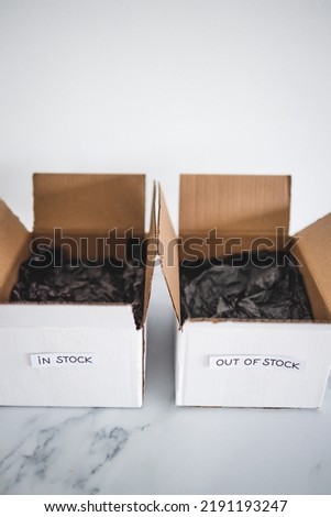 In stock vs out of stock texts inside of empty delivery parcels on white background, concept of supply chain shortages and delays after the covid-19 global pandemic