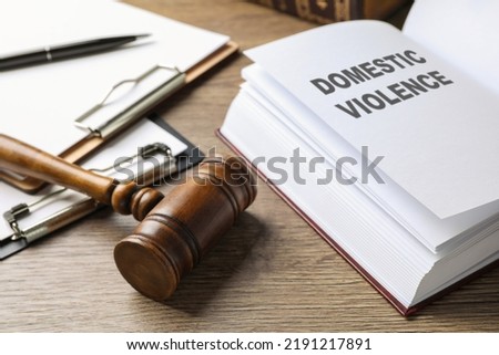 Wooden gavel and law book on wooden table. Protection from domestic violence Royalty-Free Stock Photo #2191217891