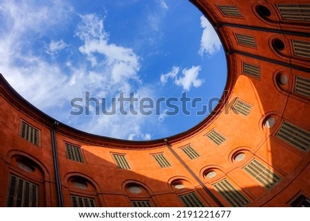 blue sky above courtyard of round elliptical old building in Ferrara, Italy as a real estate, architecture and property investing concept Royalty-Free Stock Photo #2191221677