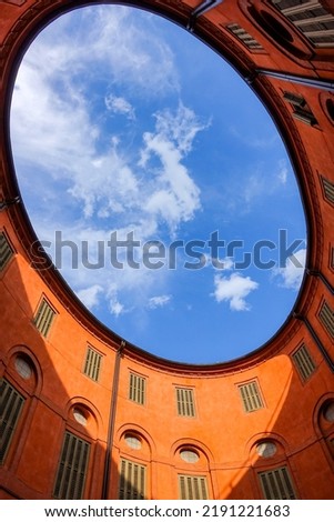 blue sky above courtyard of round elliptical old building in Ferrara, Italy as a real estate, architecture and property investing concept Royalty-Free Stock Photo #2191221683