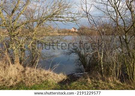 Beautiful Biesdorfer Baggersee lake surrounded by winter vegetation in January. Berlin, Germany