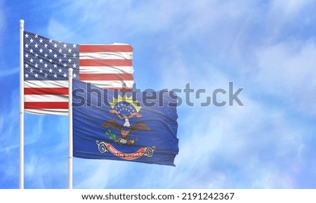 Waving American flag and flag of State of North Dakota.