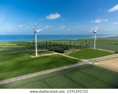 Aerial view on modern wind mills, green grain fields and blue Atlantic ocean in agricultural region Pays de Caux in Normandy, France in summer Royalty-Free Stock Photo #2191242725