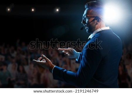 Motivational speaker with headset performing on stage Royalty-Free Stock Photo #2191246749
