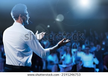 Motivational speaker with headset performing on stage Royalty-Free Stock Photo #2191246753