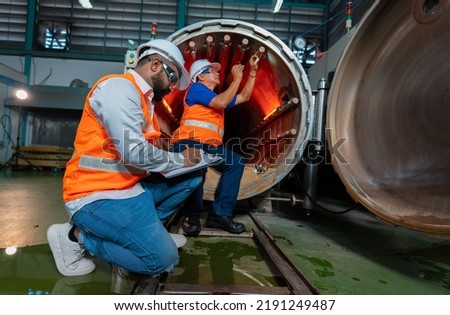 Maintenance mechanical engineer perform boiler spray nozzle leakage check inspectiion at the pressure tank during plant inoperation outage shutdown, one engineer using laptop computer recording Royalty-Free Stock Photo #2191249487