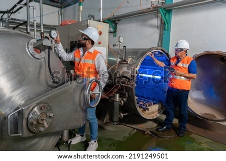Maintenance mechanical engineer perform boiler spray nozzle leakage check inspectiion at the pressure tank during plant inoperation outage shutdown, one engineer using laptop computer recording Royalty-Free Stock Photo #2191249501