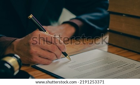 A judge's hammer and scales of justice and a jurisprudence book on a table in a lawyer's office. Provide legal advice to clients regarding business law. Law in everyday life. Royalty-Free Stock Photo #2191253371