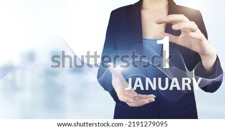 January 1st . Day 1 of month, Calendar date. Hand hold virtual hologram calendar date with digital wave.  Winter month, day of the year concept
