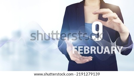 February 9th. Day 9 of month, Calendar date. Hand hold virtual hologram calendar date with digital wave.  Winter month, day of the year concept