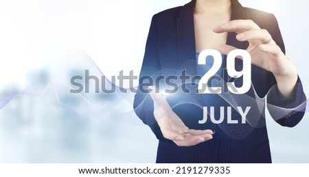 July 29th. Day 29 of month, Calendar date. Hand hold virtual hologram calendar date with digital wave.  Summer month, day of the year concept