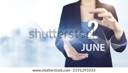 June 2nd. Day 2 of month, Calendar date. Hand hold virtual hologram calendar date with digital wave.  Summer month, day of the year concept