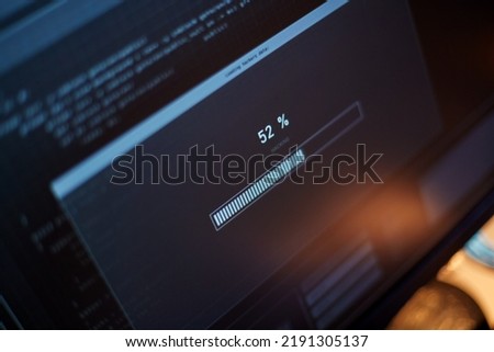 cybercrime, hacking and technology concept - close up of computer monitor with progress loading bar on screen in dark room Royalty-Free Stock Photo #2191305137