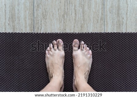 Two legs on anti-slip plastic mat to prevent slip and fall. Rubber flooring for pools and wet rooms.
 Royalty-Free Stock Photo #2191310229