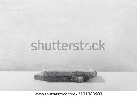 Monochrome gray template for mockup, banner. Flat granite pedestal on light gray background. Stone stand for natural design concept. Horizontal image, center composition, hard light, front view