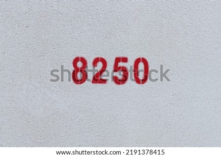 Red Number 8250 on the white wall. Spray paint.
