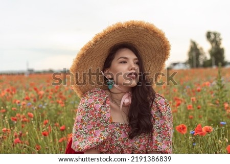 A young girl in a flowering poppy field