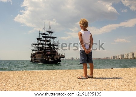 Child, visiting Thessaloniki during the summer with his pet dog and family, Greece