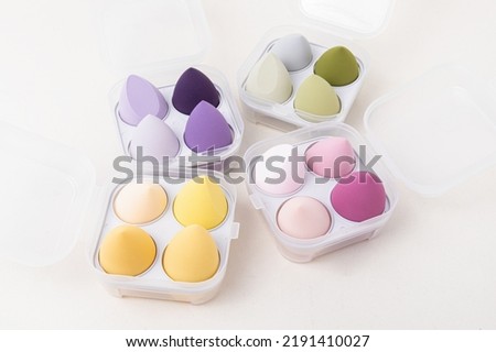 Sets of multi-colored makeup sponges on white background