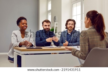 Employment and hiring. Friendly human resources commission interviewing woman during meeting in office. Female candidate for position sits in front of commission and talks about herself.