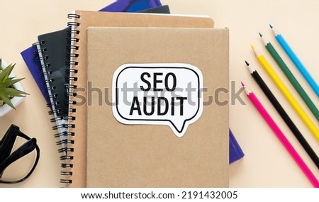 SEO AUDIT text on paper on notebook on a yellow table.