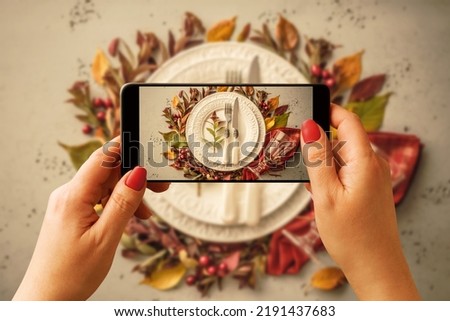 Woman taking photo of autumn (fall) table setting design idea with smartphone. Blogger, influencer or stylist capturing Thanksgiving home decorations for social media.