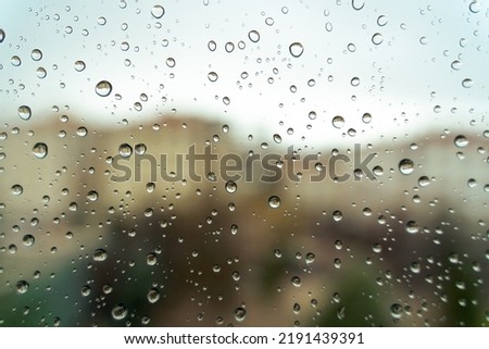 Raindrops on window, blurry background. Close-up view, selective focus.