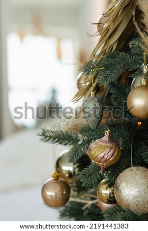 Gold balls on a Christmas tree with a window in the background.