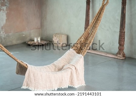 Comfortable hammock in stylish light boho room. Interior design. Romantic, cozy vibes. Real photo.
