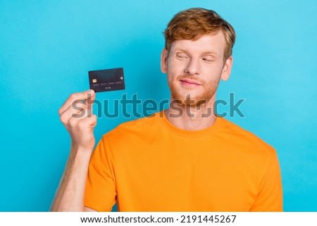 Photo of funny ginger hair guy look card wear orange t-shirt isolated on teal color background