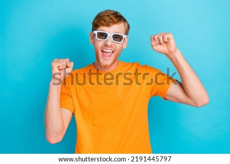 Photo of astonished ginger hair guy watch film wear orange t-shirt eyewear isolated on turquoise color background