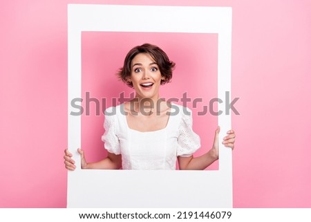 Photo of excited impressed lady wear white blouse looking inside photo frame isolated pink color background