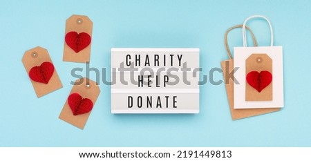 International Day of Charity, September 5. Charity, give help, donations, support, humanitarian aid day concept with text message on lightbox, red paper heart  on blue background.