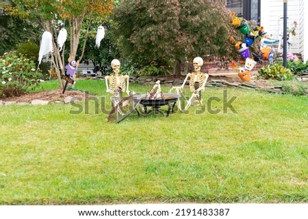 Decoration of the facade of the house for the holiday of Halloween. Pumpkin skeletons and terrible monsters on the lawn.