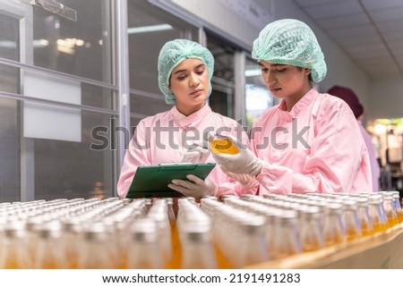 Indian engineers drink factory glass bottles Inspecting production fruit juice drinks that have been produced in large numbers by wearing tight protective clothing order best quality before being sell Royalty-Free Stock Photo #2191491283