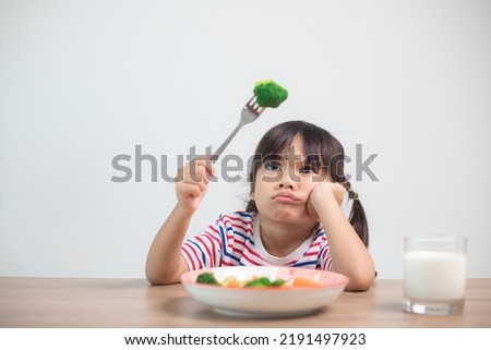 Nutrition healthy eating habits for kids concept. Children do not like to eat vegetables. Little cute girl refuses to eat healthy vegetables. Royalty-Free Stock Photo #2191497923