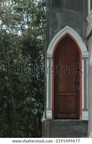 a single wooden door next to bamboos