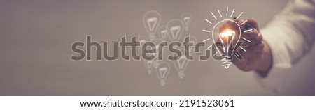 light bulb with shining halo cartoon style hand drawn style doodle style Symbolic concept of creativity, innovation, inspiration, invention and ideas. Royalty-Free Stock Photo #2191523061