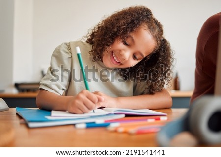 Learning, smiling and creative young girl drawing with a colorful pencil feeling happy and content. Positive student with a smile having a fun time creating artistic art in her kids notebook at home