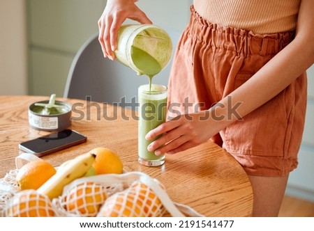 Closeup of a female pouring green healthy smoothie to detox, drinking vitamins and nutrients. Woman nutritionist having a fresh fruit juice to cleanse and provide energy for healthy lifestyle Royalty-Free Stock Photo #2191541477
