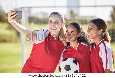 Selfie, soccer and sports team smiling and feeling happy while posing for a social media picture. Diverse and young girls standing together on a football field. Friends and teammates enjoying a