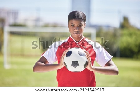 Soccer, football and sports with player, woman and athlete ready for a match, game or competition with ball on a pitch, field or stadium outdoor. Portrait of serious black female ready for training Royalty-Free Stock Photo #2191542517